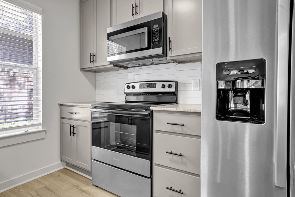 a kitchen with stainless steel appliances and white cabinets