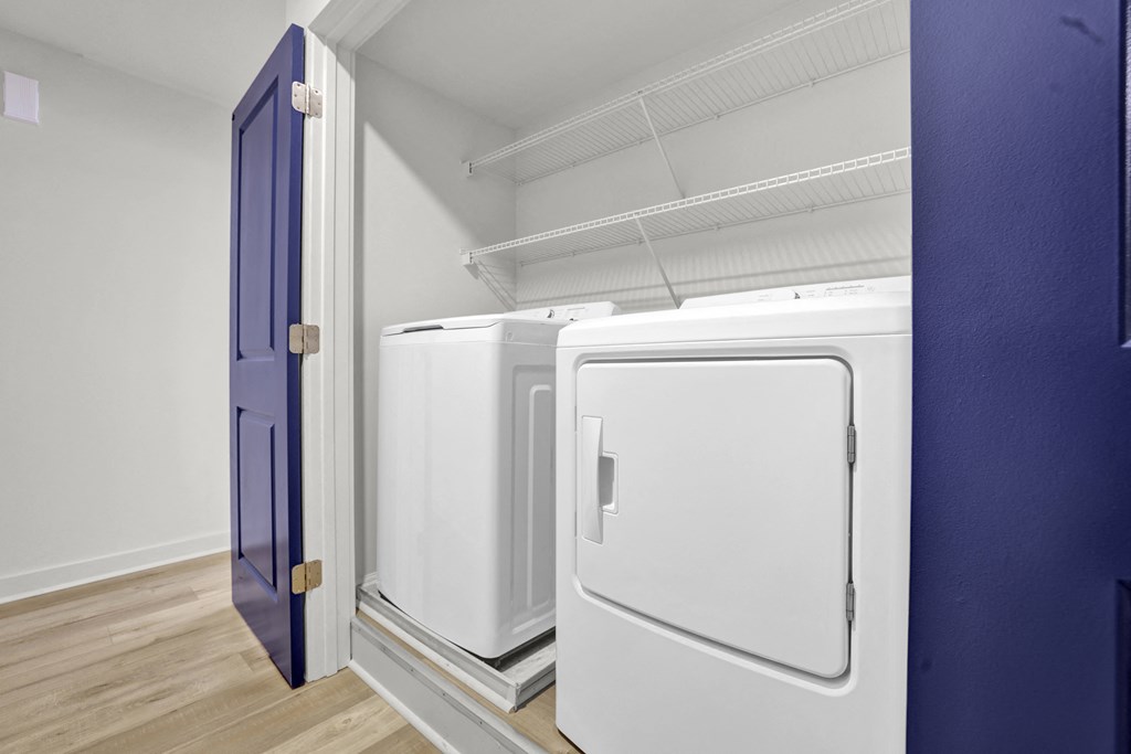 three refrigerators in a room with a blue door