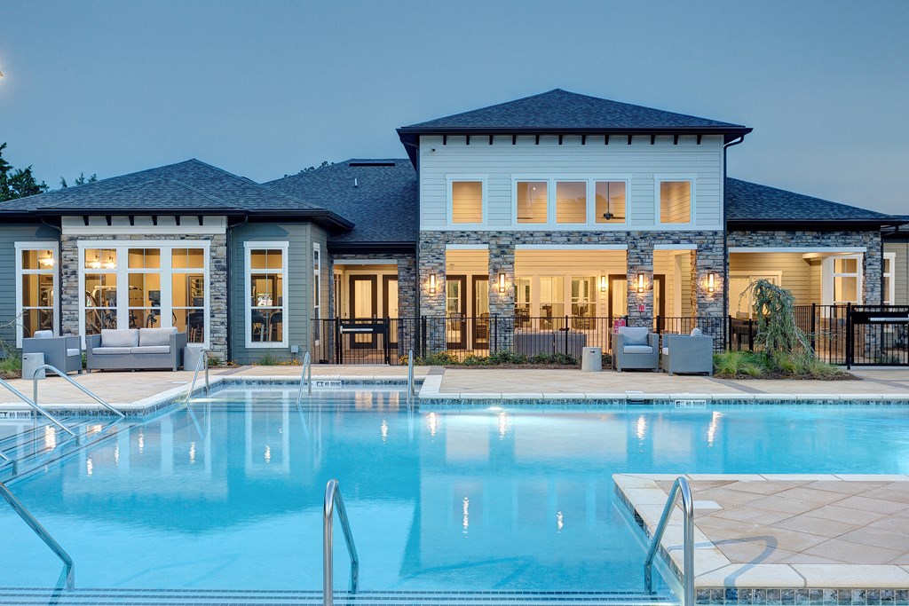a swimming pool in front of a house with a pool