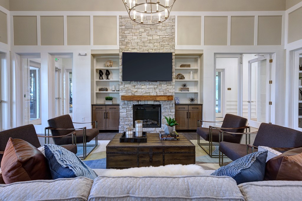 a living room with a stone fireplace and a tv above it