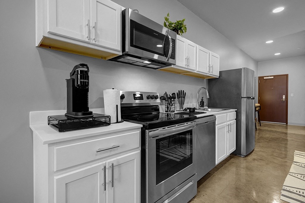 a kitchen with stainless steel appliances and white cabinetry