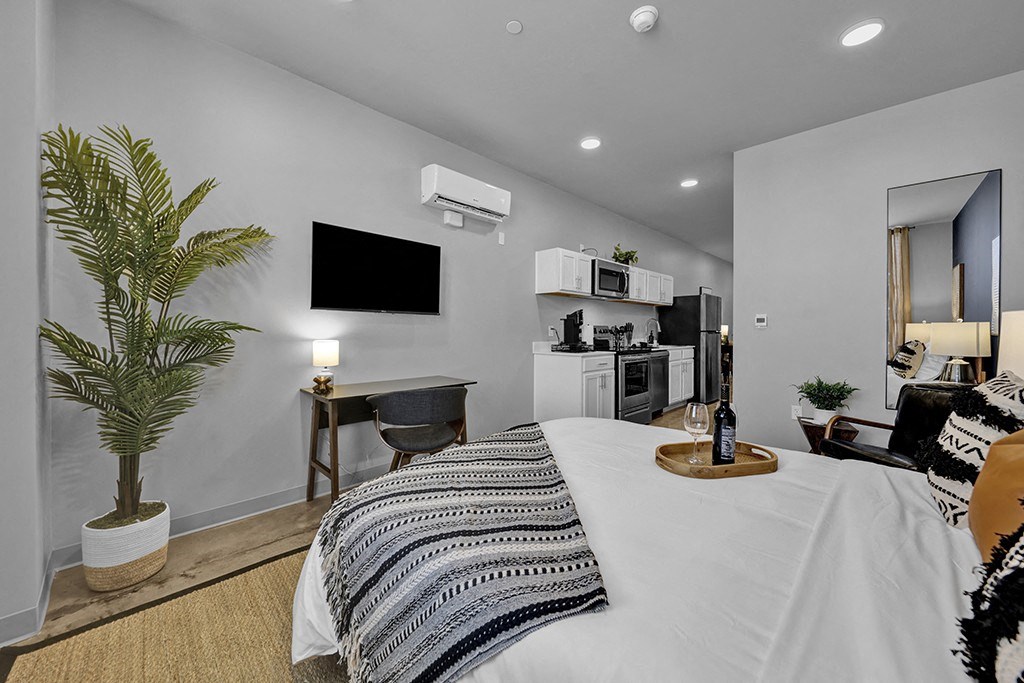 Birmingham, AL - A Studio Apartment With High Ceilings, Historic Concrete Flooring, An AC Unit, And Access To The Kitchen Area.