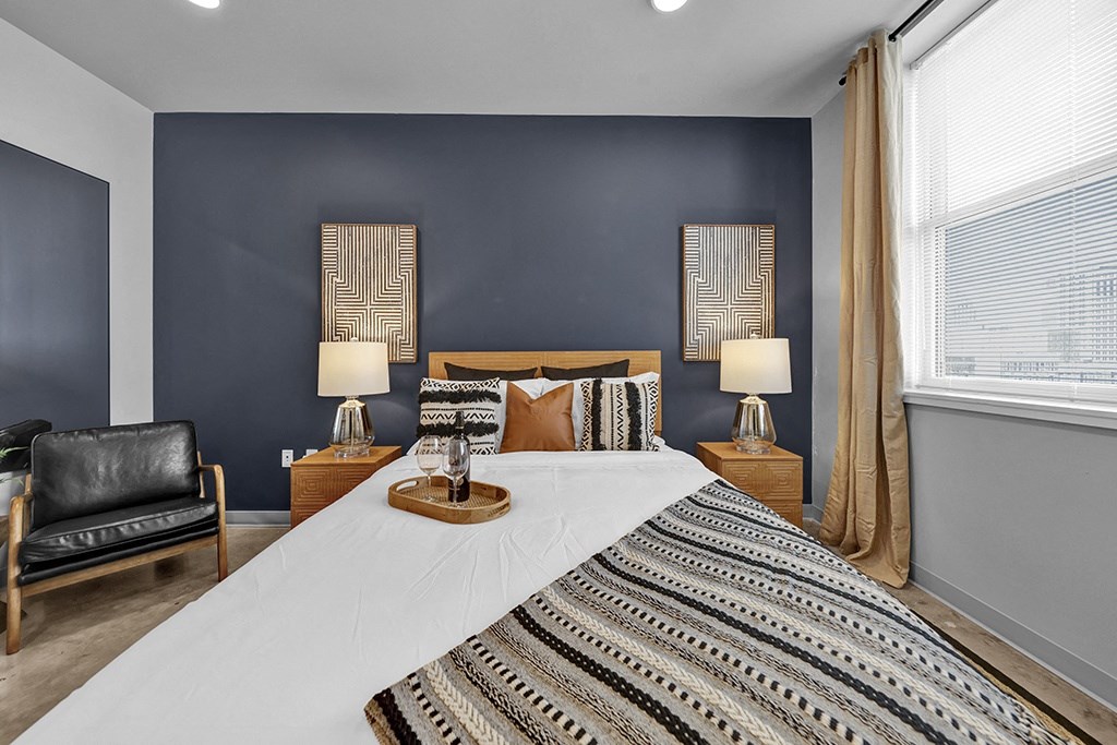 a bedroom with a bed and two windows