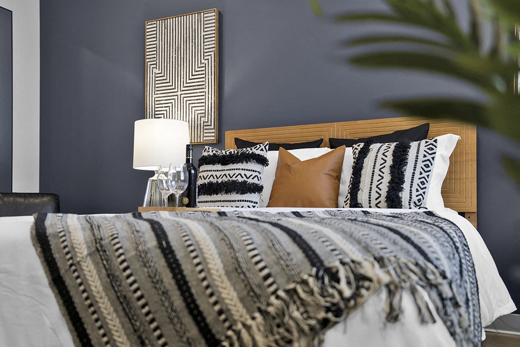 a bedroom with blue walls and a bed with pillows and a blanket