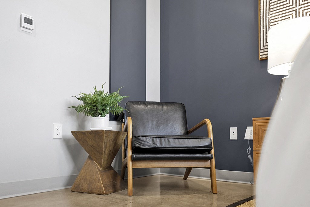 a leather chair next to a table with a potted plant