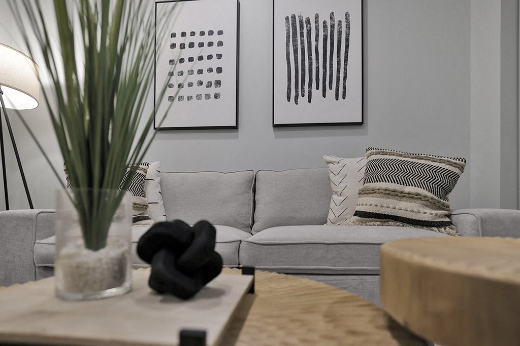 a living room with a couch and a table with a vase