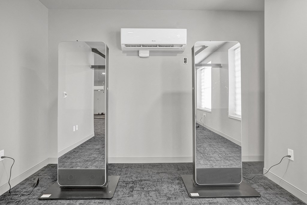 two mirrors in a room with white walls