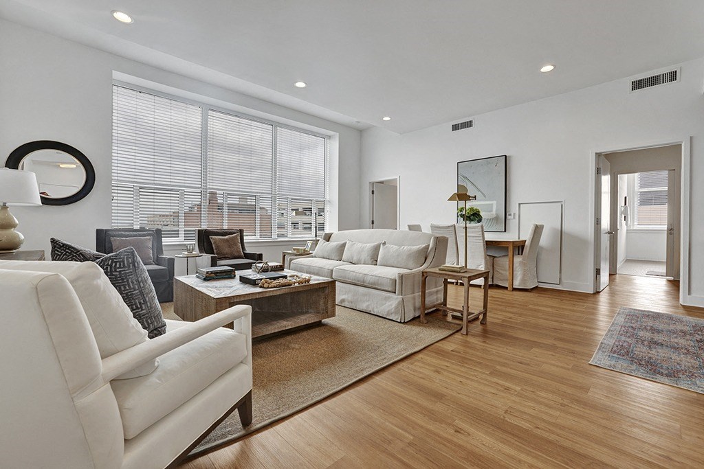 a living room with white furniture and a large window