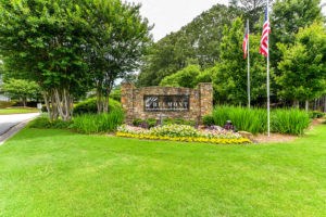 a park with two flags and a sign in the grass