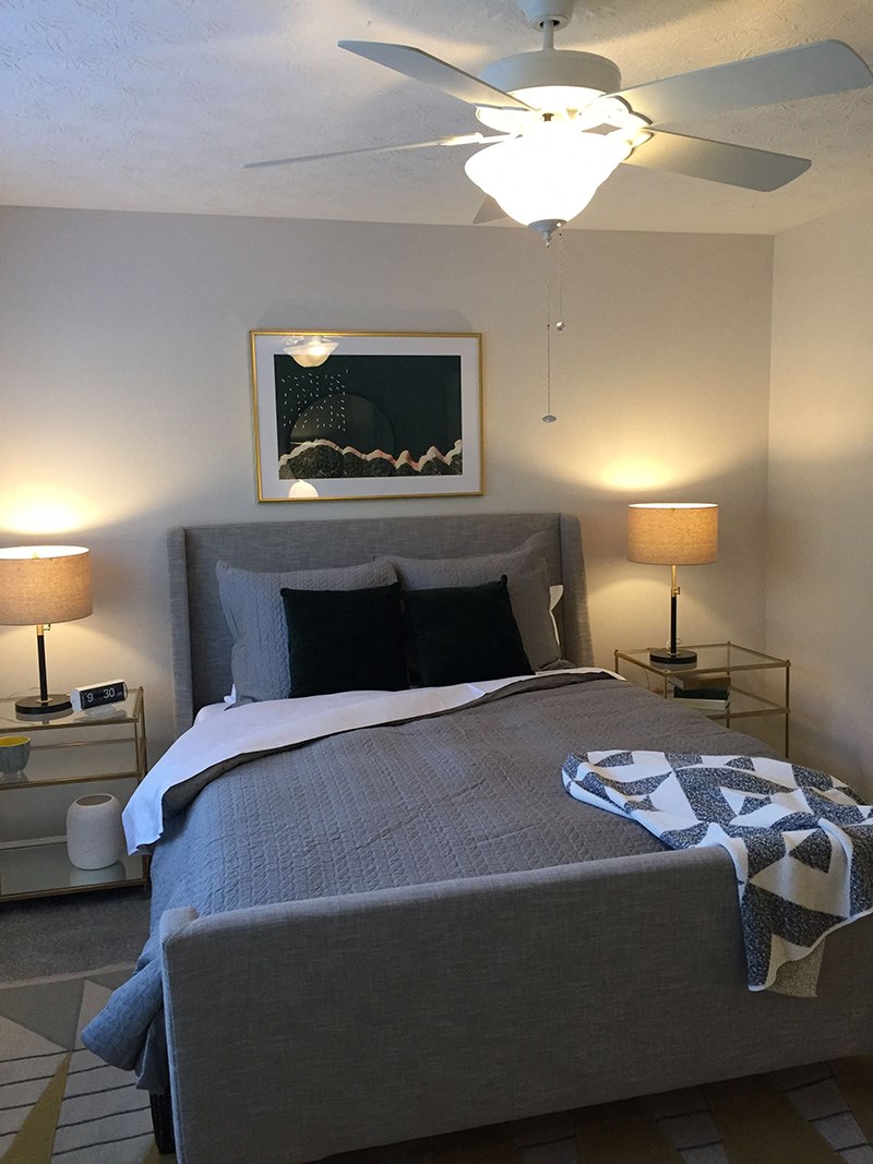 a bedroom with a bed and a ceiling fan