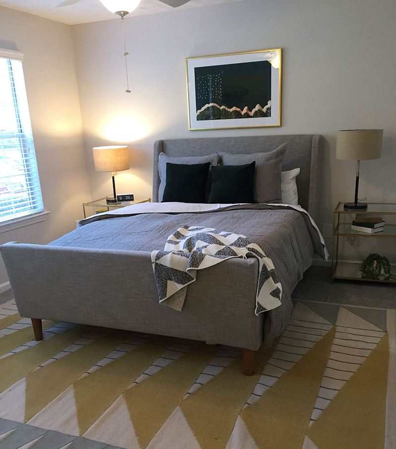 a bedroom with a bed with a blanket and pillows on it