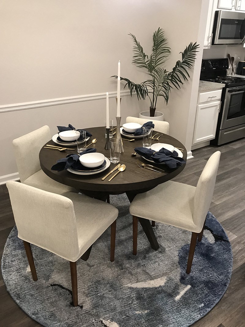 a dining room with a round table and white chairs