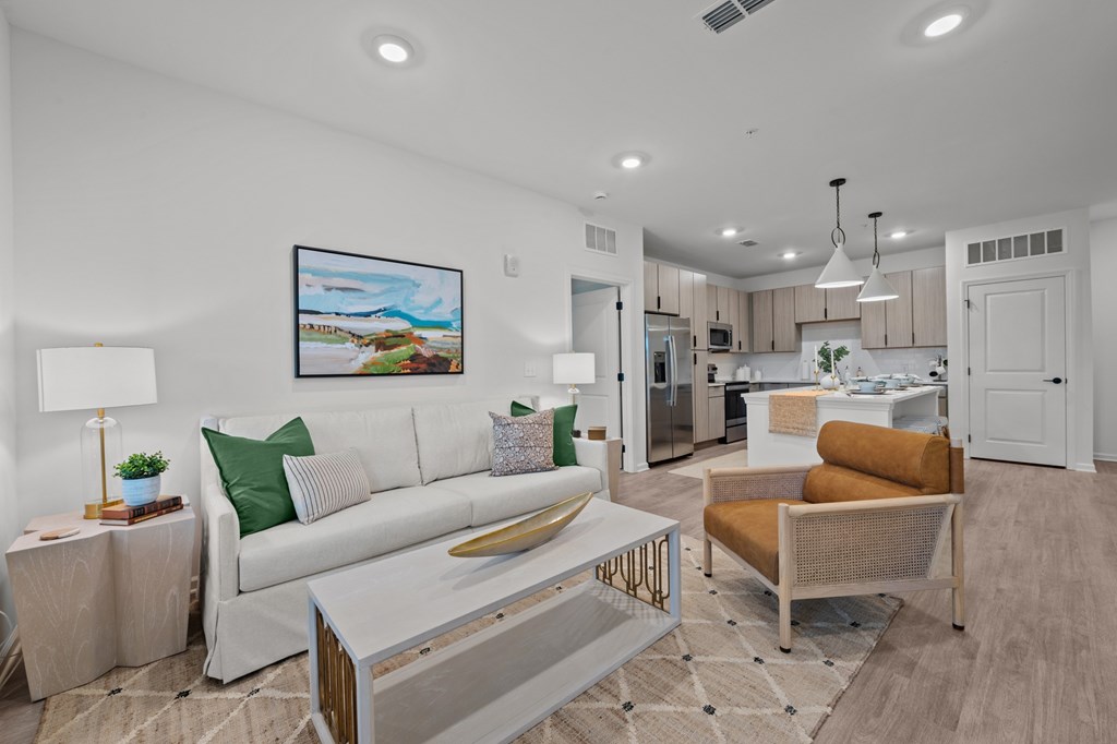 A modern living room with a white couch and a painting on the wall.