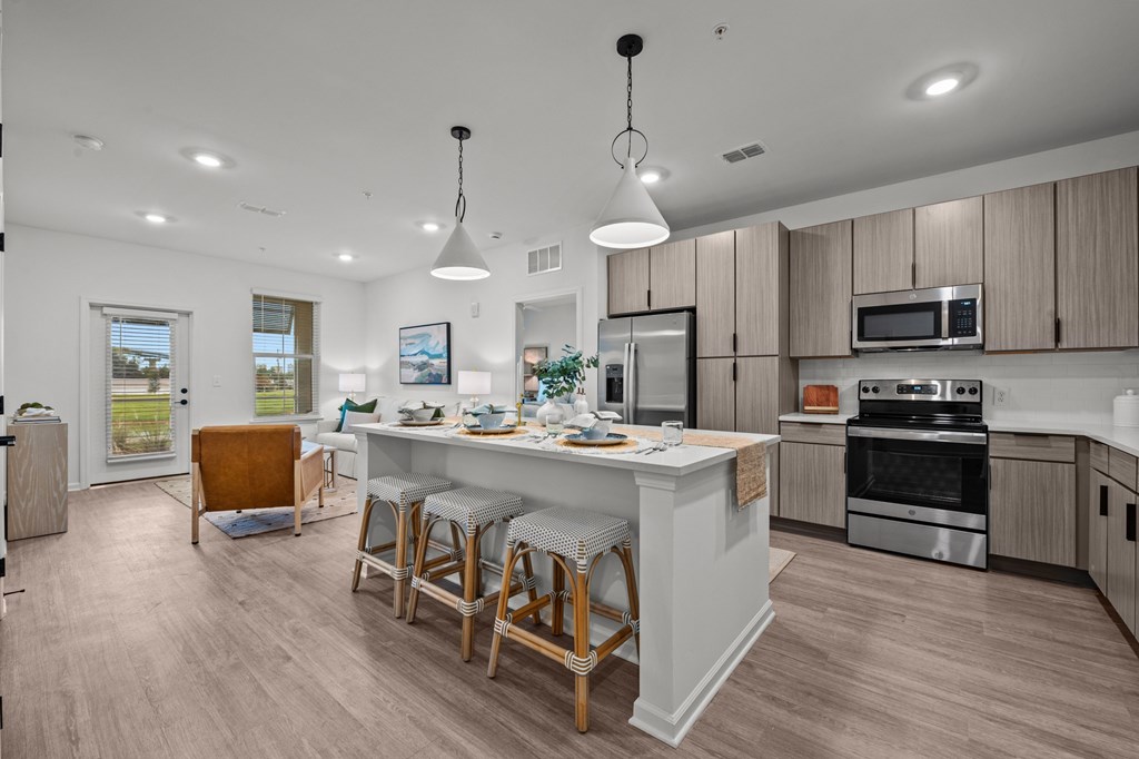 A kitchen with a white island and wooden bar stools.