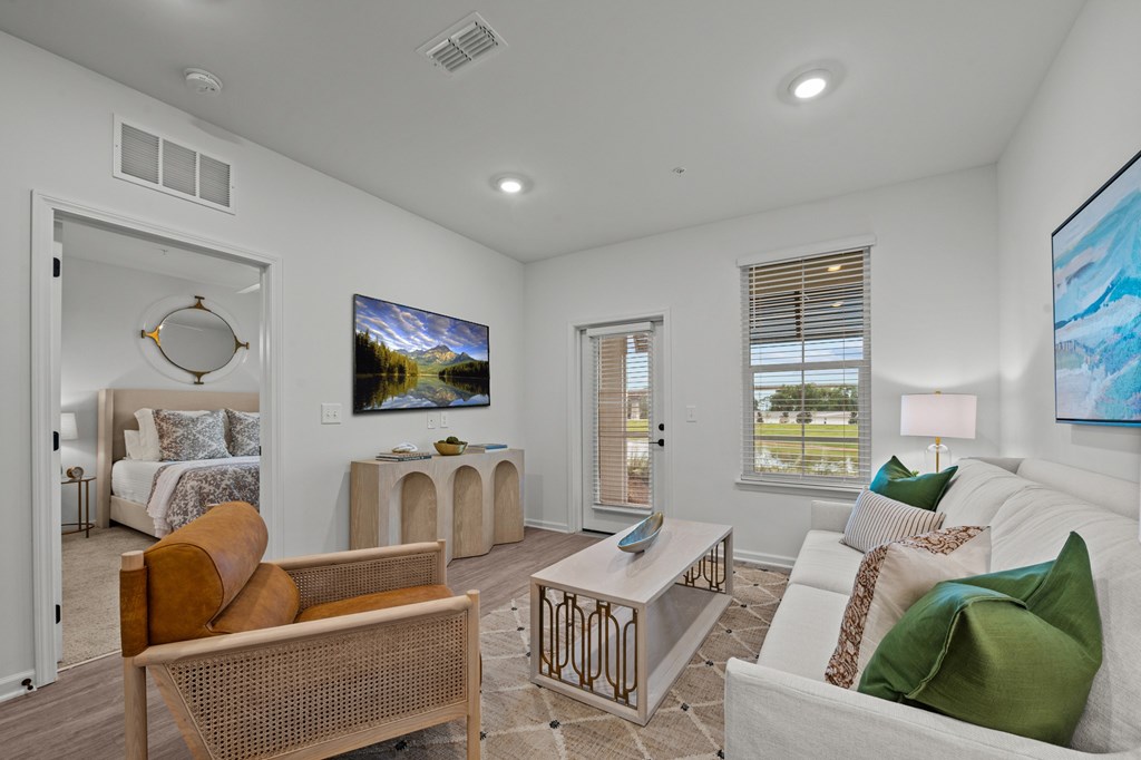 A living room with a white couch and a painting on the wall.