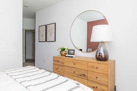a bedroom with a bed and a dresser with a mirror