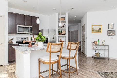 a kitchen with a island and two chairs in front of a counter