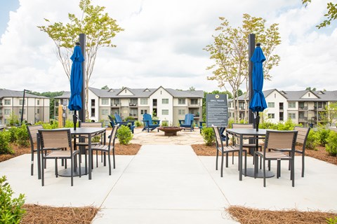 an outdoor patio with tables and chairs and a fire pit