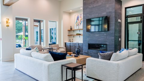 A modern living room with a white couch and a fireplace.
