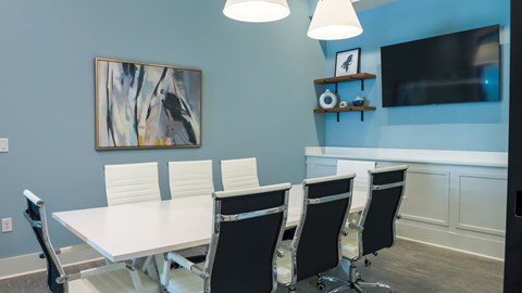 The Flats at East Bay Apartments – conference room with seating for eight and a large tv display