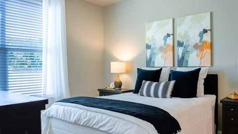 A bedroom with a large bed and a painting on the wall.