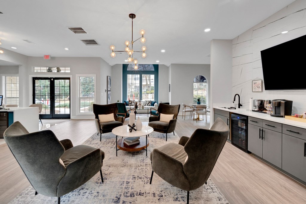 a living room with chairs and a table and a television