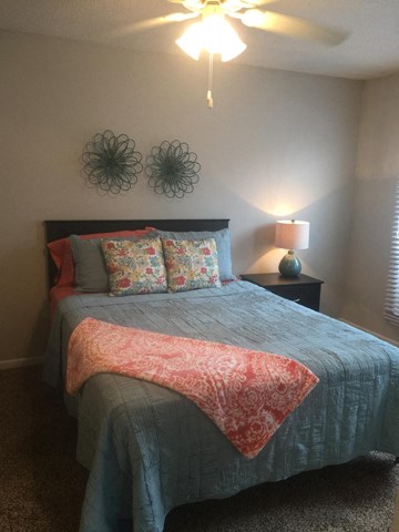 a bedroom with a bed with a blue comforter and pillows