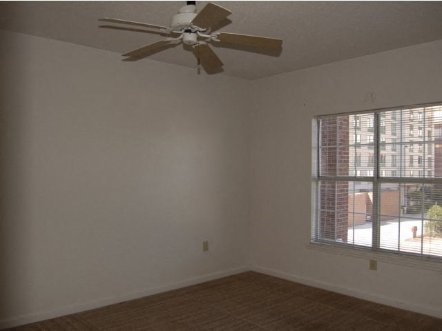 a living room with a ceiling fan and a window