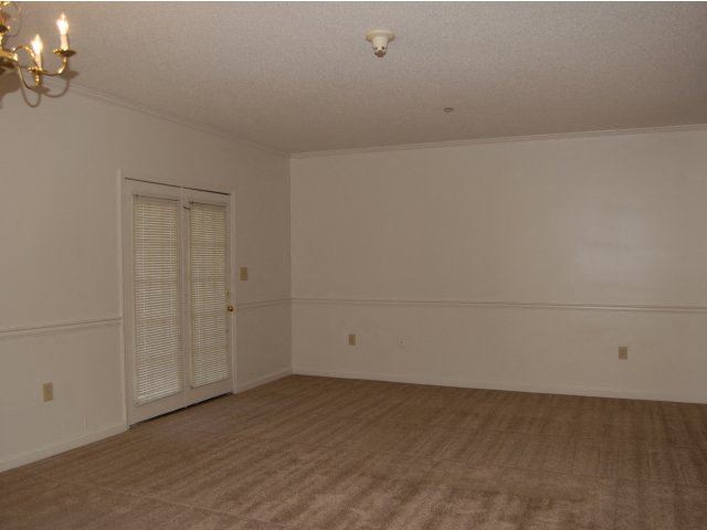 an empty living room with white walls and a door