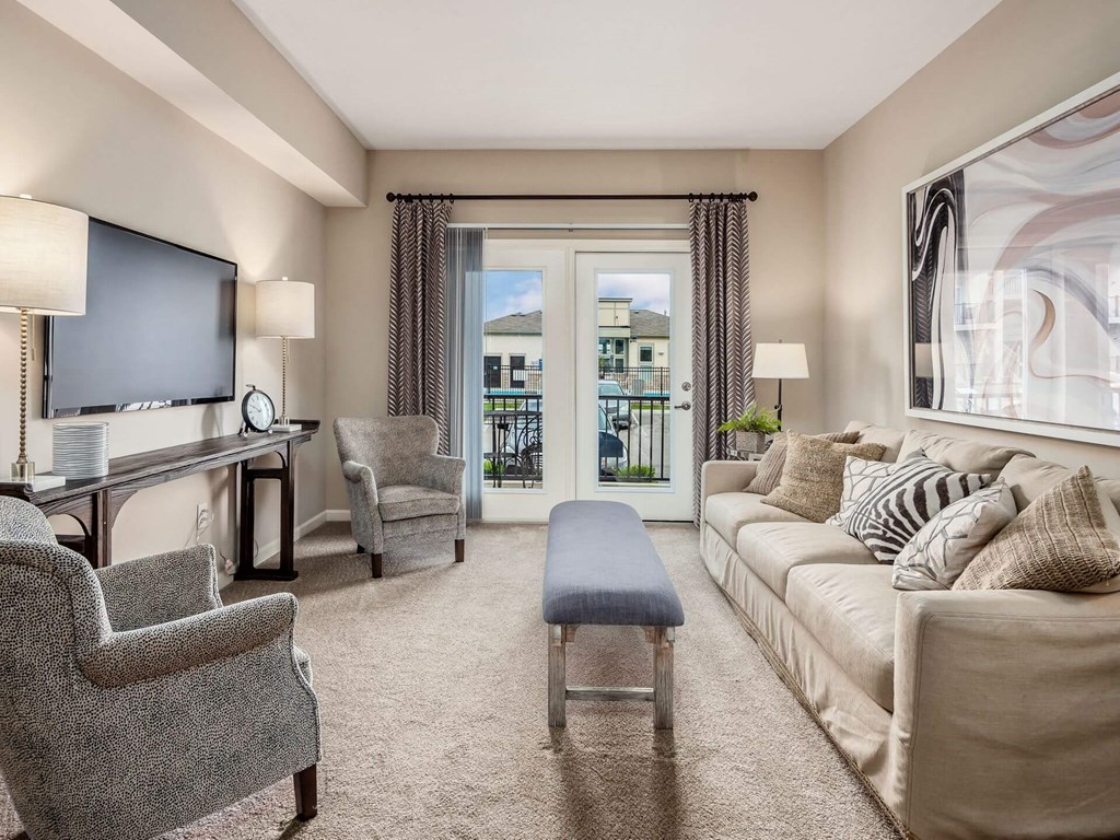 a living room with a couch and chairs and a television