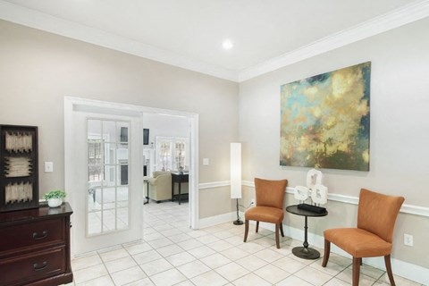 a living room with a painting on the wall and a door that leads to a dining room