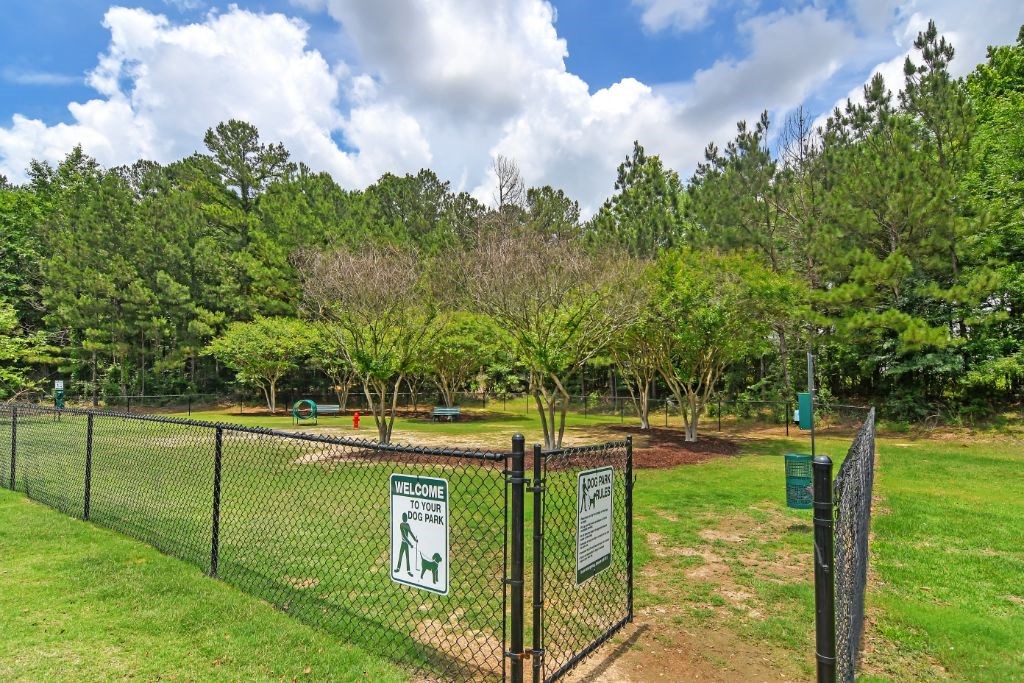 a dog park with green grass and trees