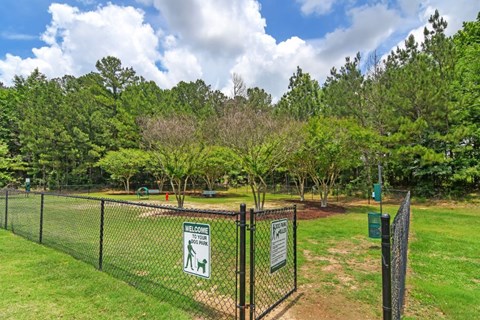 a dog park with green grass and trees