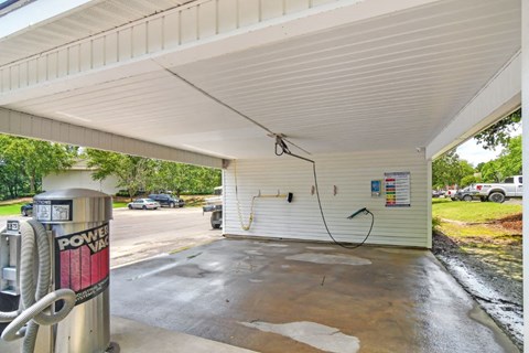 a gas pump in a parking lot with a car in the background
