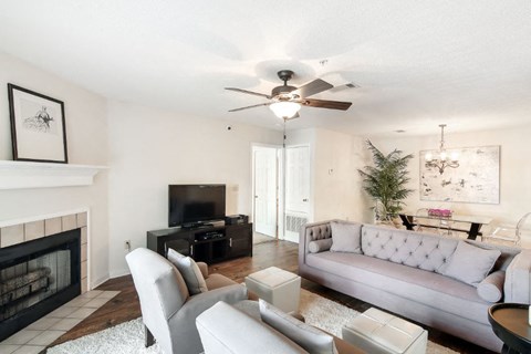 a living room with a fireplace and a ceiling fan