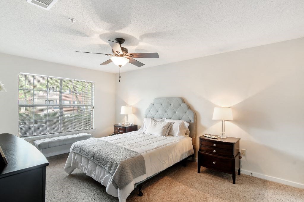 a bedroom with a bed and a ceiling fan