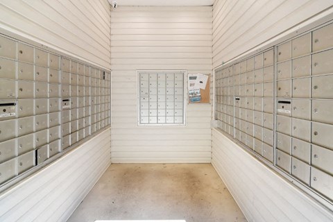 a lockers room with white walls and a bulletin board on the wall