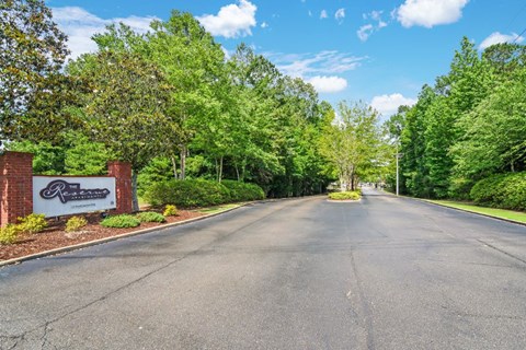 a street with a sign and trees on both sides of the street