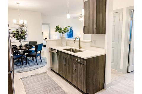 a kitchen with a sink and a dining room with a table