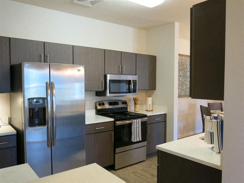 a kitchen with a stove a refrigerator and a microwave