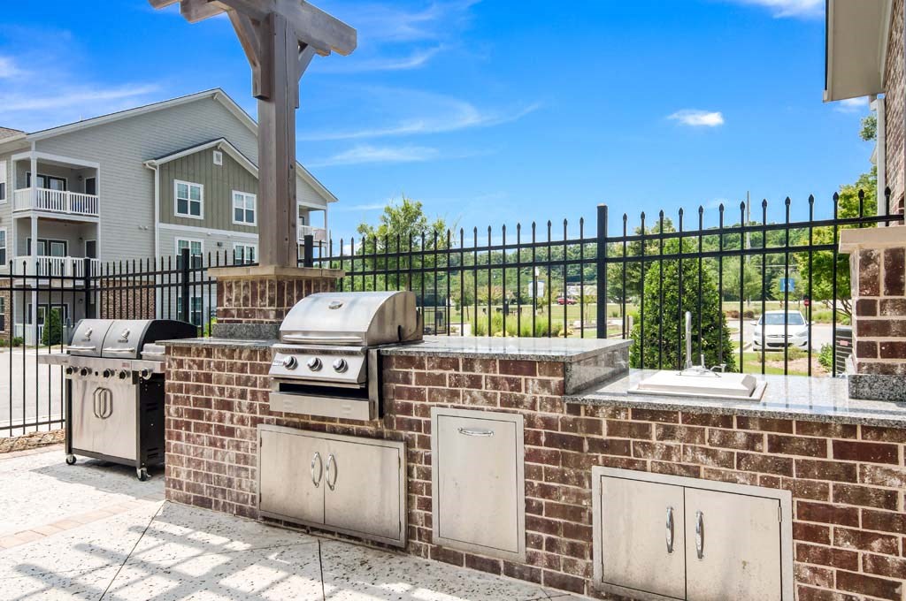an outdoor kitchen with a grill and a sink