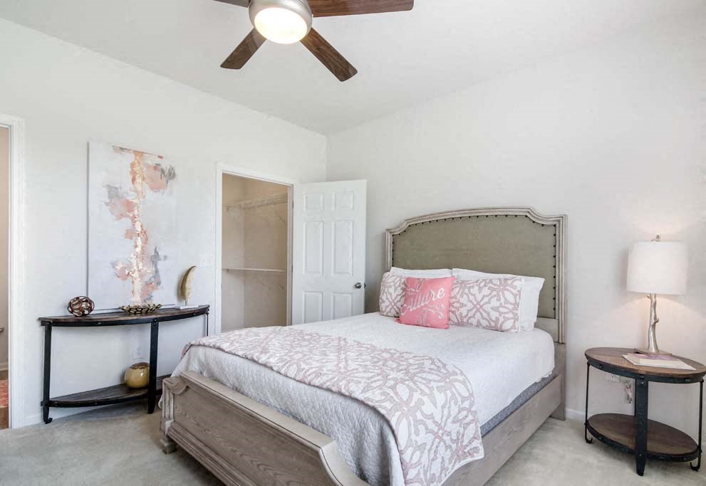 a bedroom with a bed and a ceiling fan