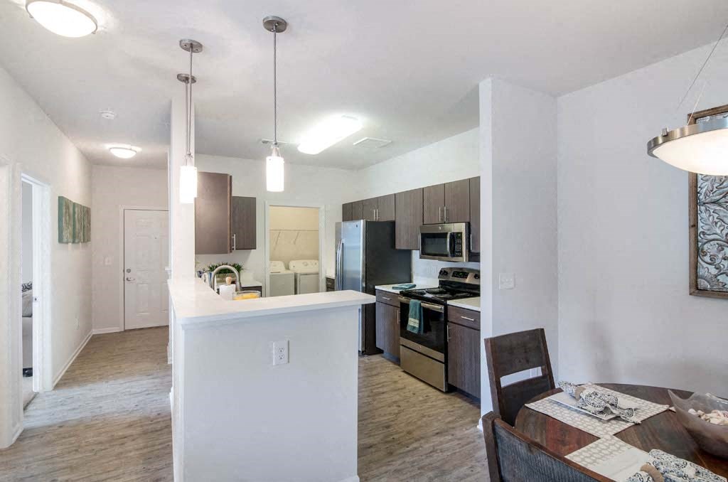 a kitchen and a dining room with a table and chairs