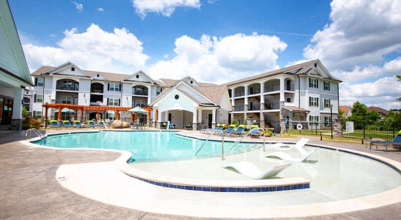 a large swimming pool with apartments in the background