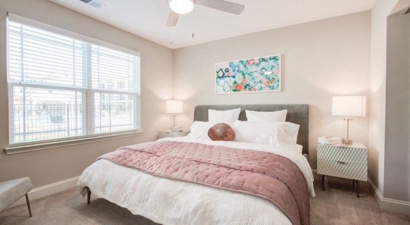 a bedroom with a bed and two windows