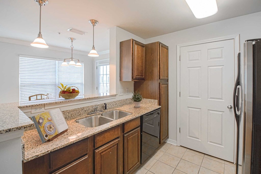 a kitchen with a sink and a refrigerator at 10X Audubon Park apartments in Daphne, AL 