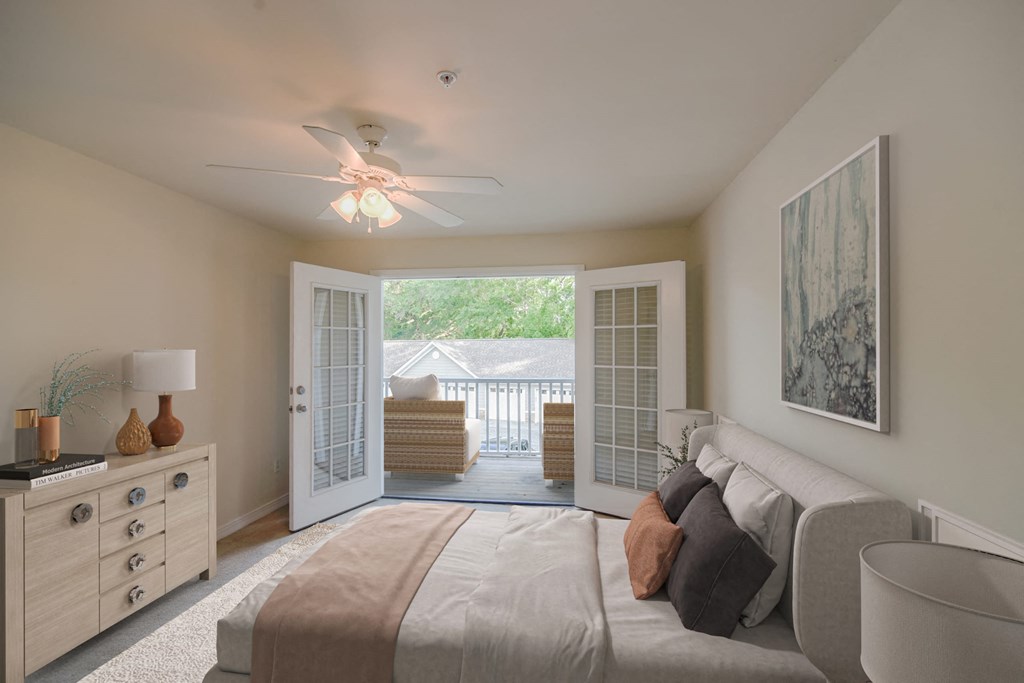 a bedroom with a bed and a ceiling fan at 10X Audubon Park apartments in Daphne, AL 