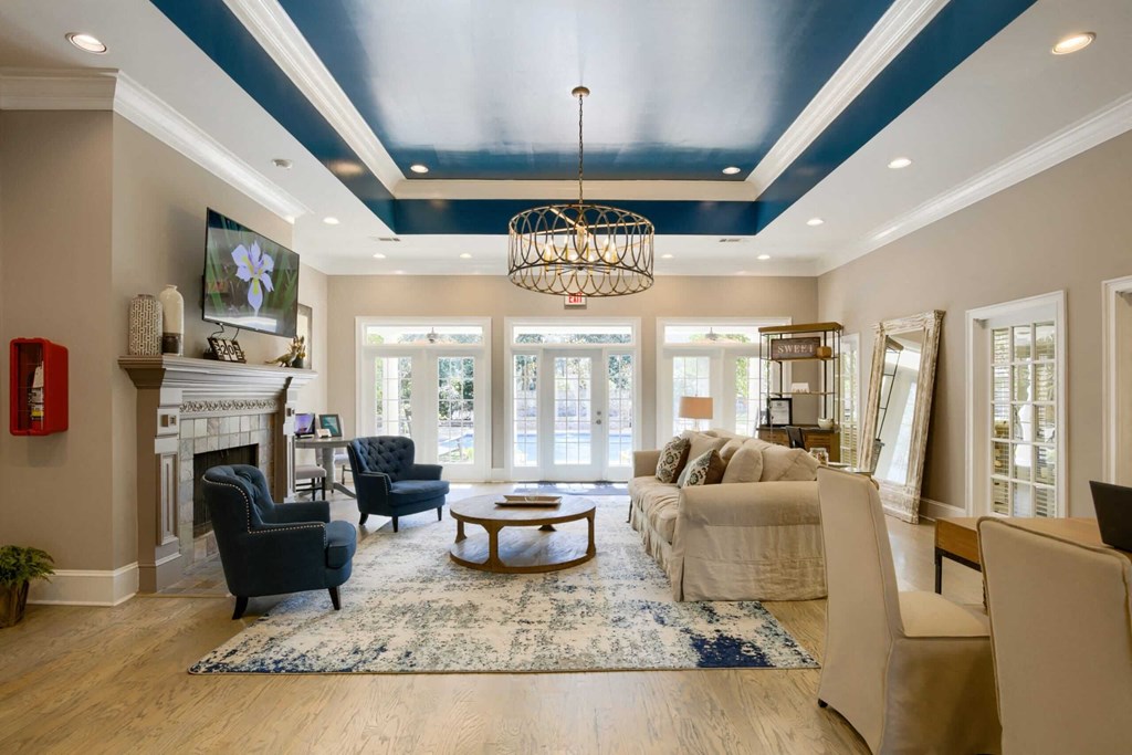 A living room with a fireplace and a large window at 10X Audubon Park apartments in Daphne, AL 