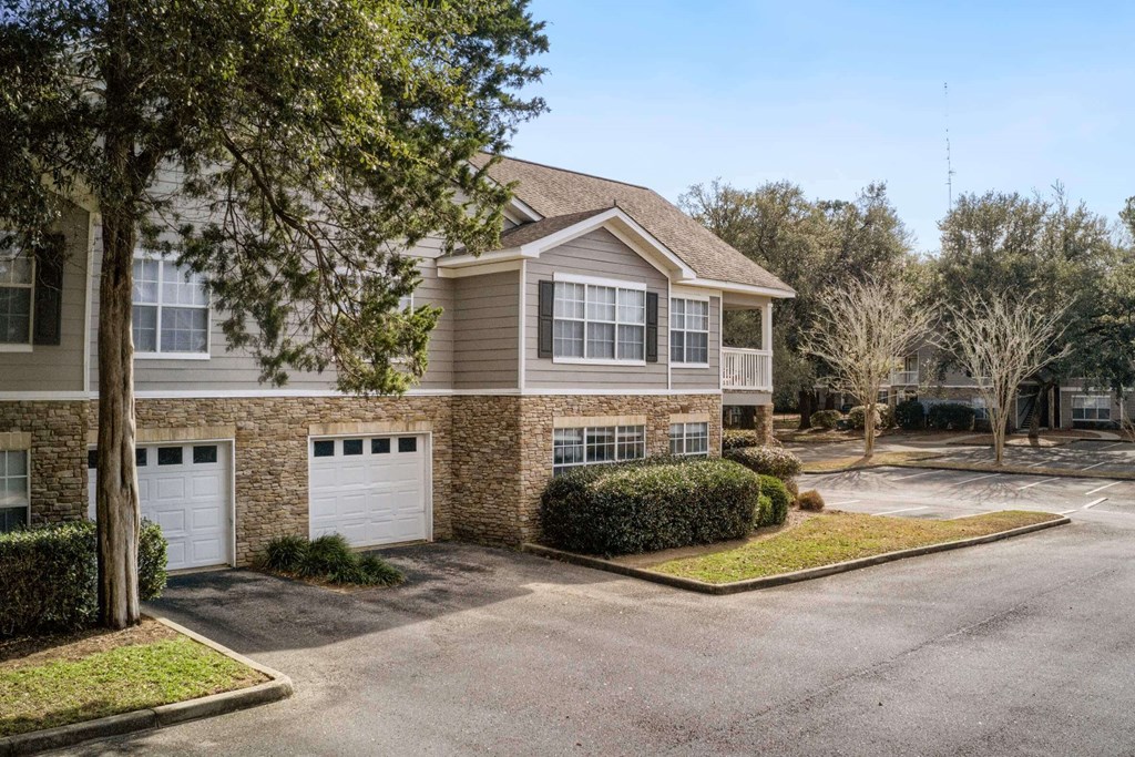 A residential building with a driveway and garage doors at 10X Audubon Park apartments in Daphne, AL 