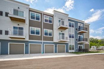 an apartment building with balconies and a sidewalk